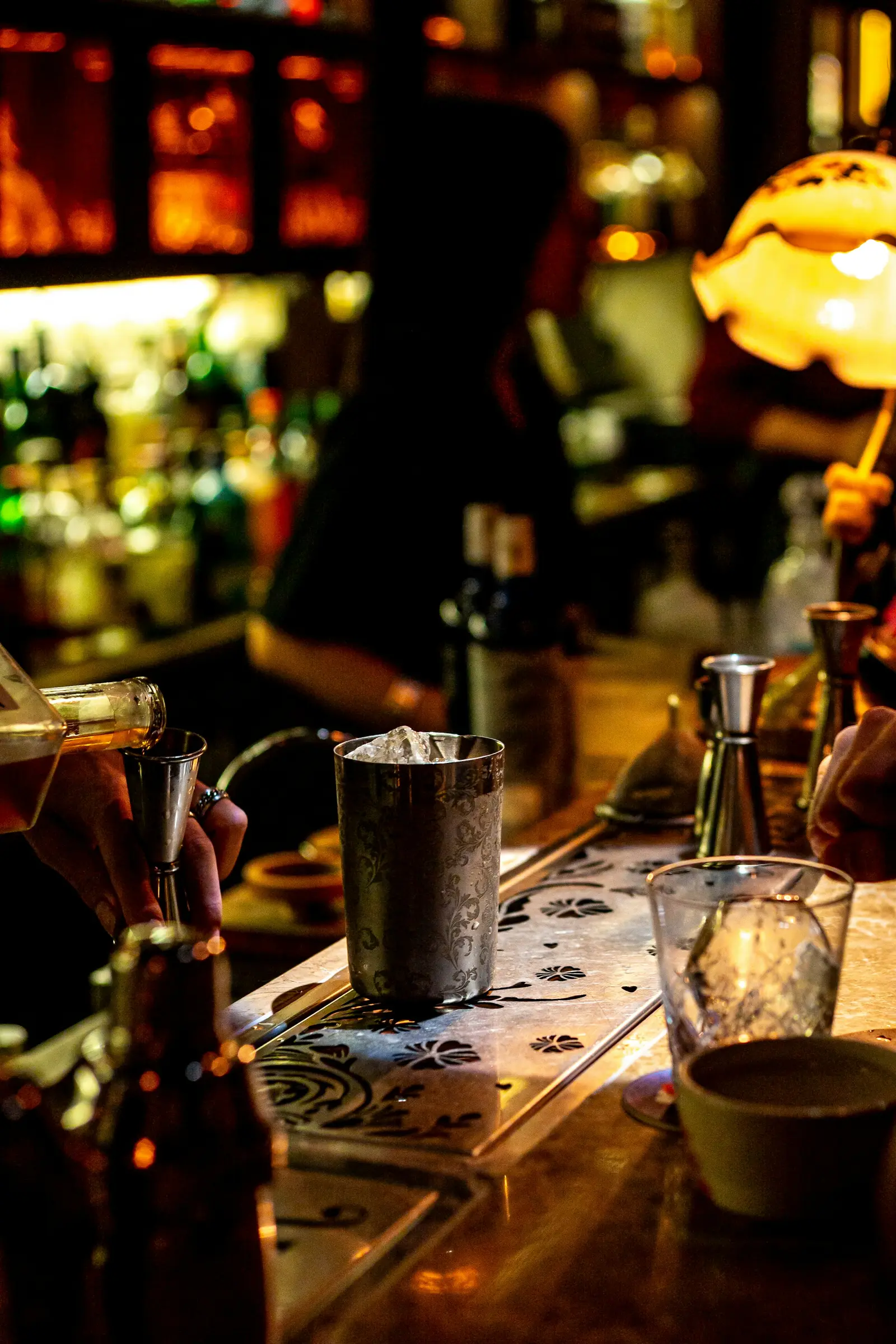 A bartender preparing a drink in a dim bar
