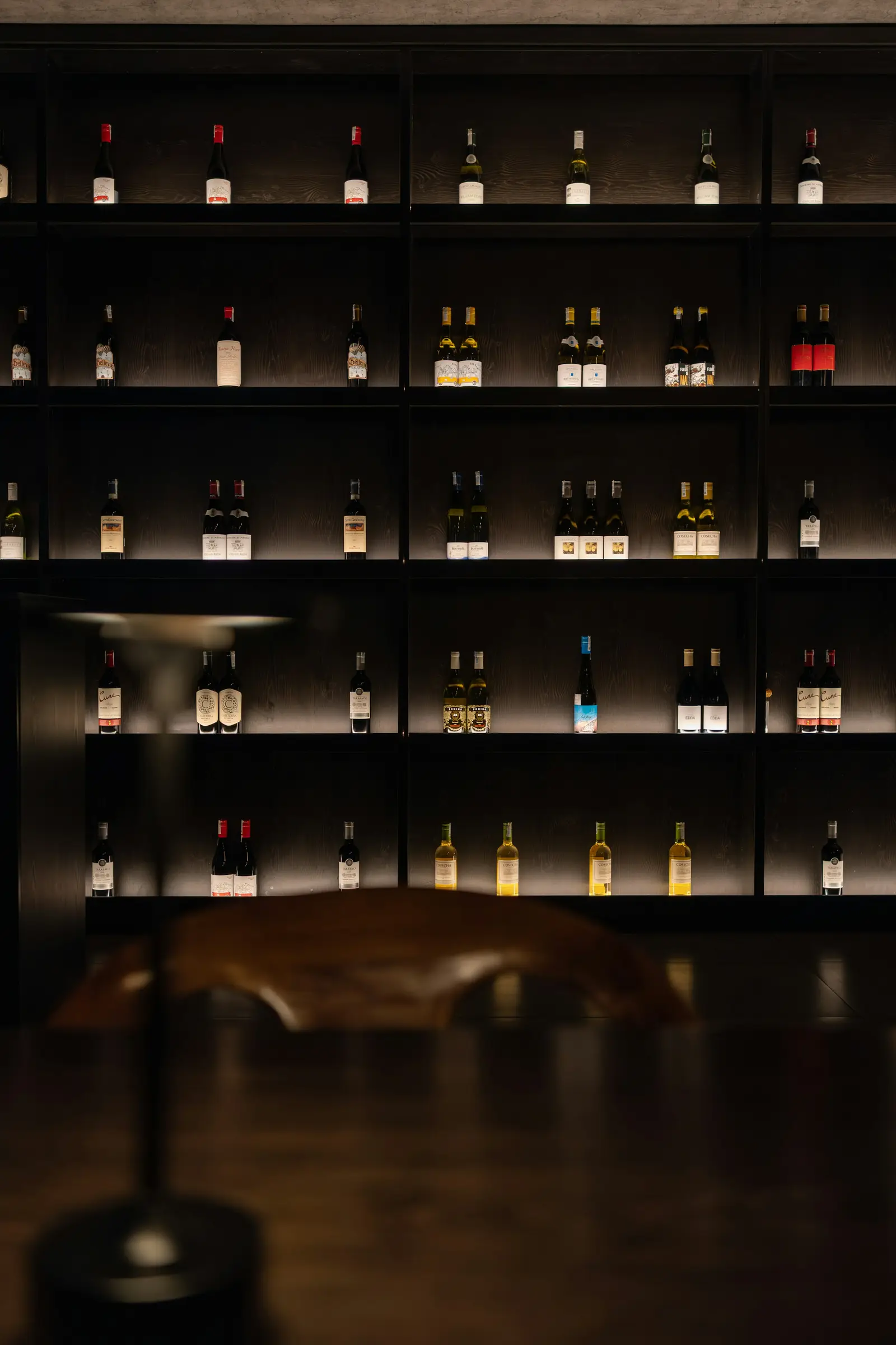 Wine bottles resting in a dimly lit cellar