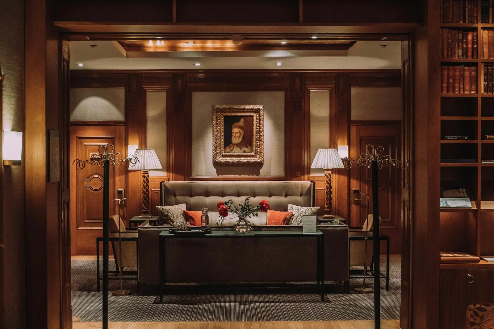 A wood-panelled lounge with lamps